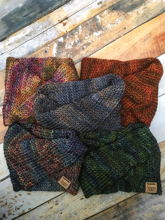 Five merino headwraps against a wood background. Each headwrap is a different color blend.