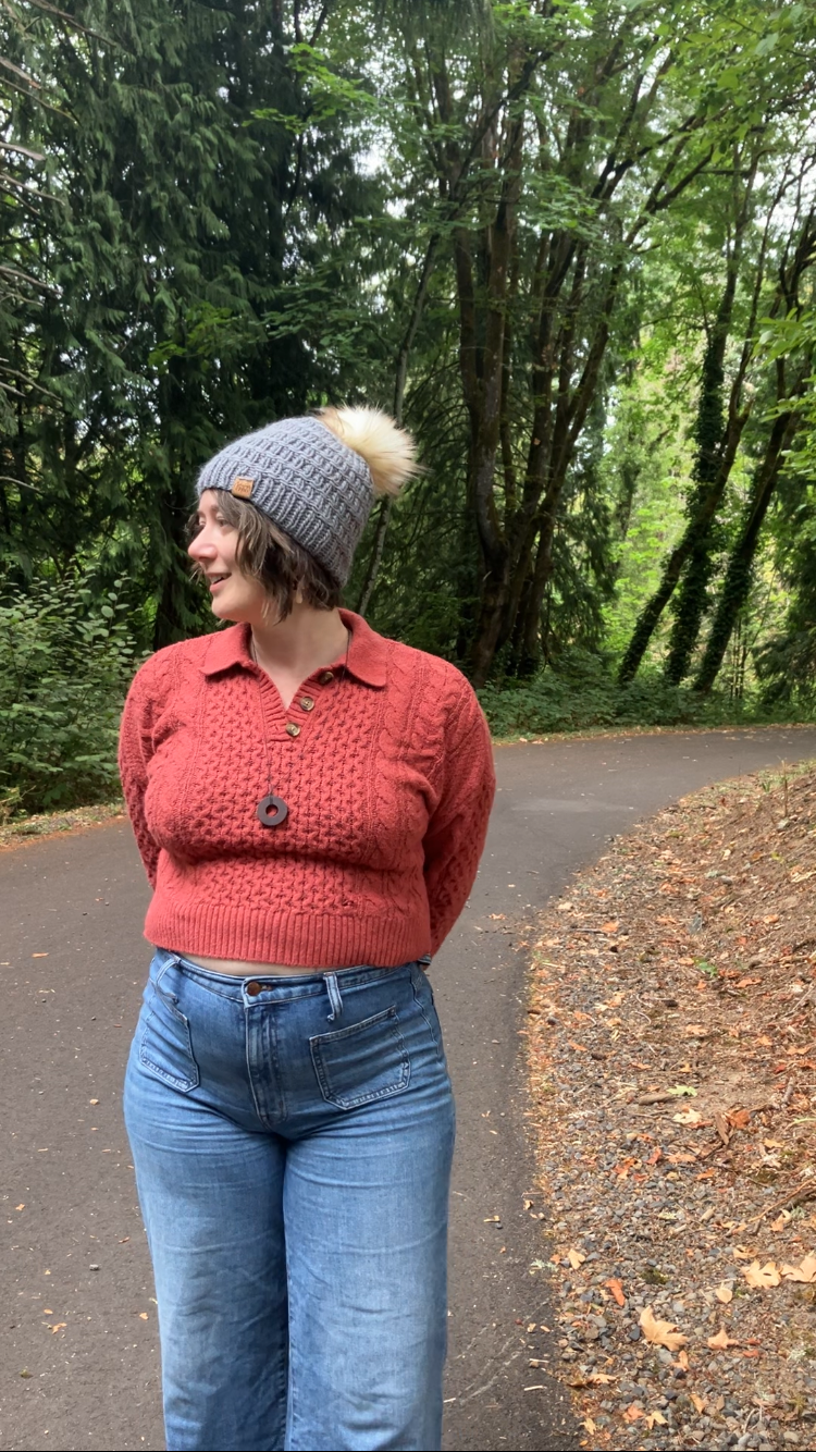 The Messenger Beanie in gray with cream pom shown on a model on a hiking trail.