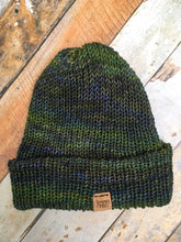 Load image into Gallery viewer, The Hadrosaur Hat is a lightweight, double layered slouchy beanie with folded brim.  It is shown here in green/blue in a flat lay.
