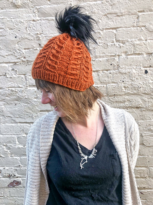 Fossil Beanie in copper with black pom.  It is shown here on a model.