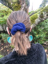 Load image into Gallery viewer, The Cotton Scrunchy is a simple knit hair accessory.  It is show here in navy on a model in a ponytail.
