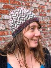 Load image into Gallery viewer, The Find Your Way Beanie has a chevron stripe pattern in two colors.  It is shown here on a model in white and light rainbow.
