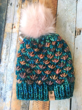 Load image into Gallery viewer, Lotus Beanie in teal with brown flowers and pink pom.  It is shown here in a flat lay.
