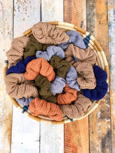 Load image into Gallery viewer, A basket of knit scrunchies in five colors.

