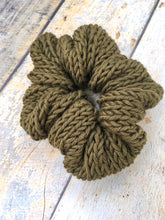 Load image into Gallery viewer, The Cotton Scrunchy is a simple knit hair accessory. It is show here in olive in a flat lay.
