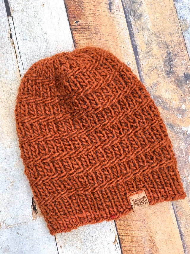 Messenger Beanie in copper without pom. It is shown here in a flat lay.