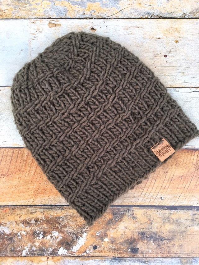 Messenger Beanie in olive without pom. It is shown here in a flat lay.