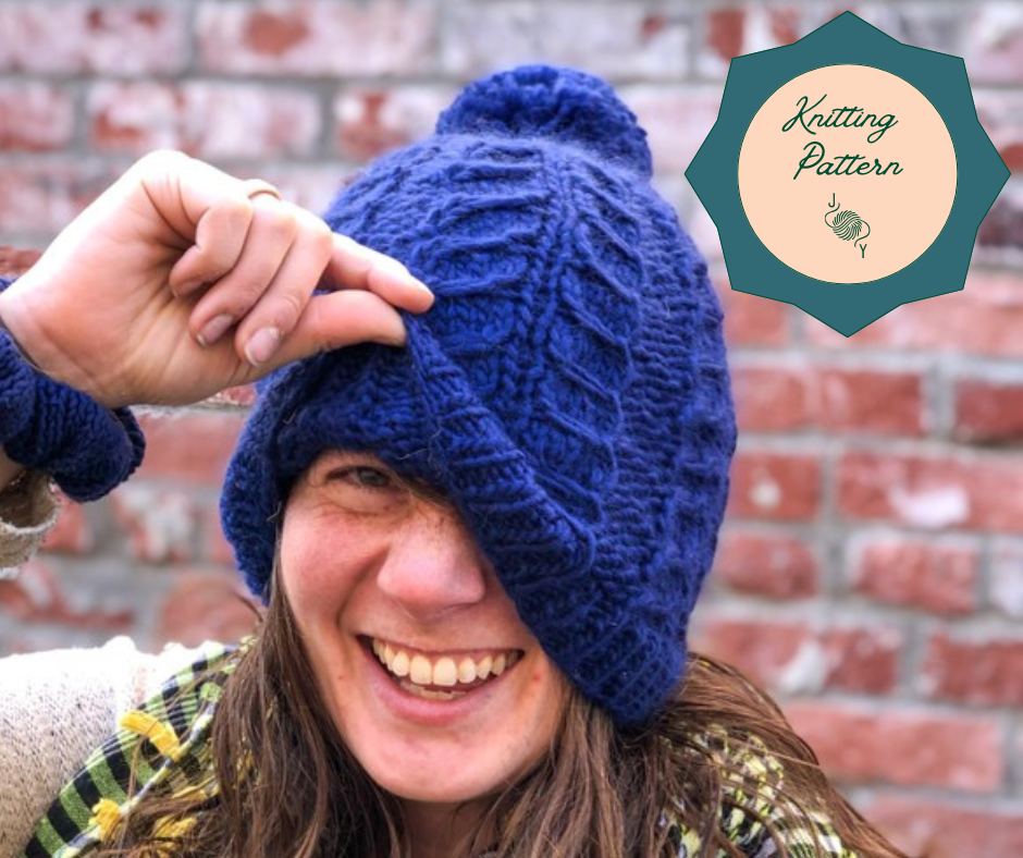 Blue Fossil Beanie with cabled pattern in bulky shown on a model with a circle that says "knitting pattern".