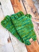 Load image into Gallery viewer, T Rex Mitts in green in a flat lay against a wooden background.
