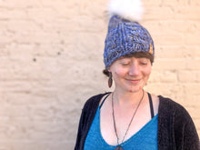 Load image into Gallery viewer, Witch Hazel Beanie in light blue with white pom. It is shown here on a model.
