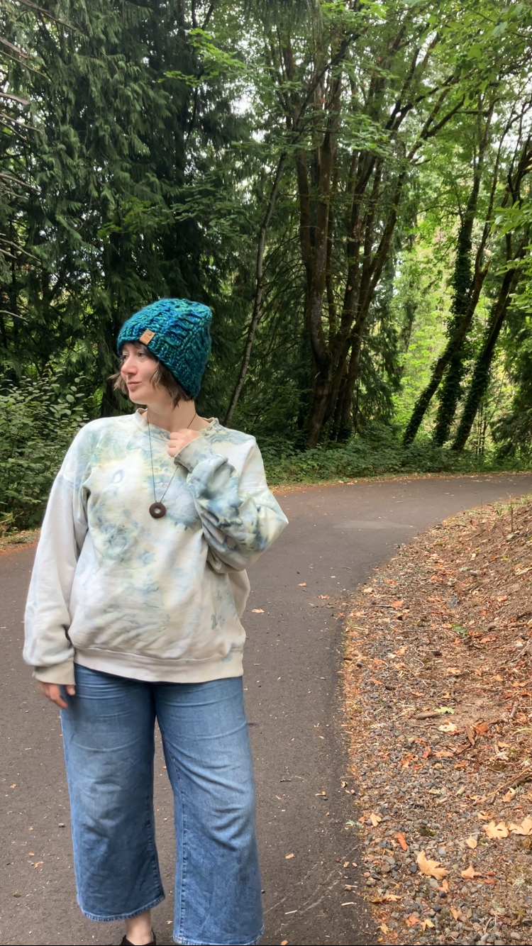 Fossil Beanie in teal without pom.  It is shown here on a model on a hiking trail.