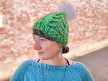 Load image into Gallery viewer, Fossil Beanie in green with white pom.  It is shown here on a model.
