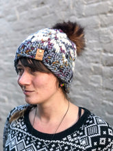 Load image into Gallery viewer, Snowflake Beanie in gray with white snowflake and brown pom.  It is shown here on a model.
