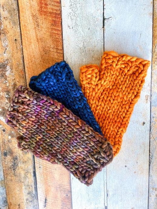 Flat lay showing fingerless gloves in three colors:  brown, dark blue, and orange.