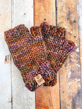 Load image into Gallery viewer, T Rex Mitts in brown in a flat lay against a wooden background.
