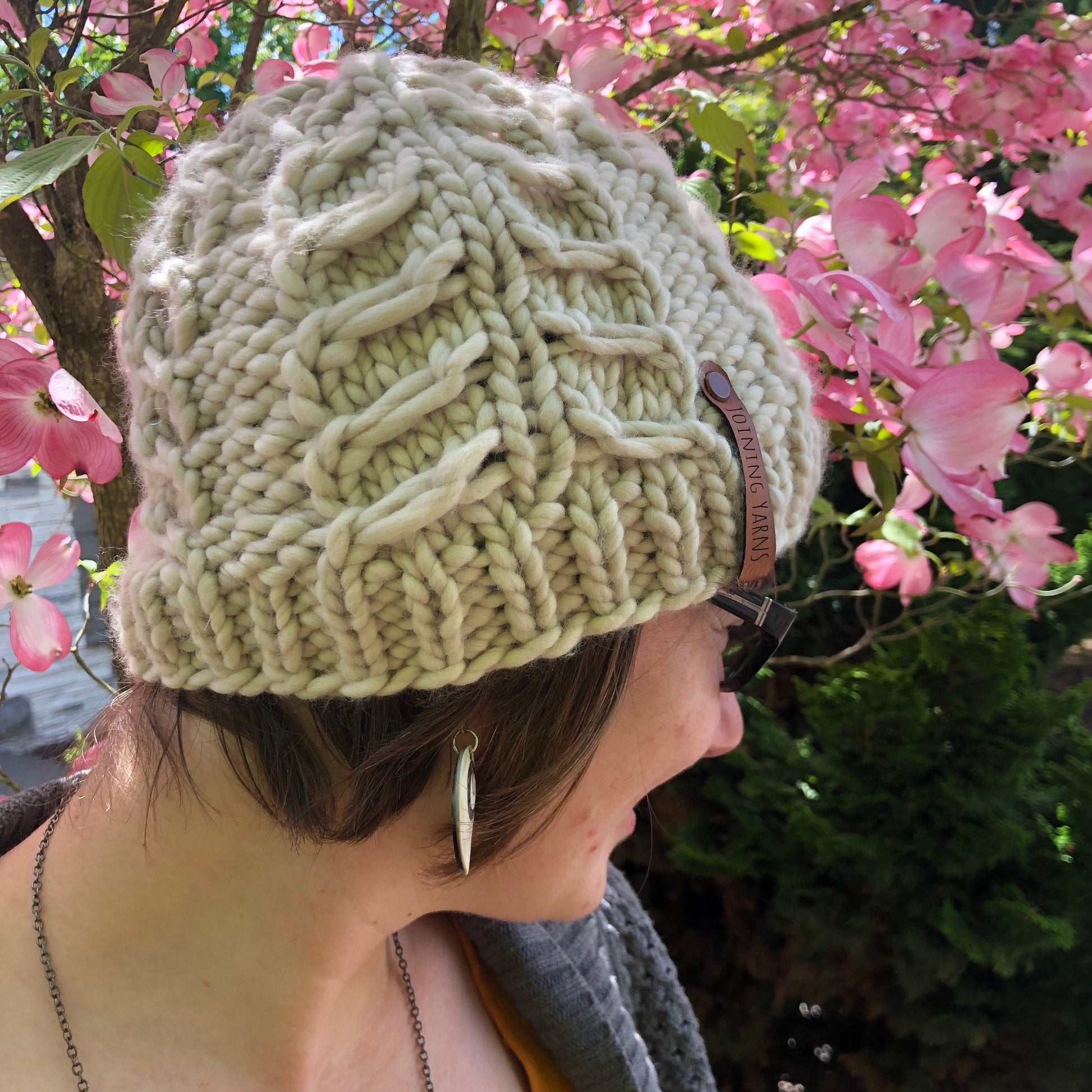 The Fossil Beanie in super bulky is shown in white on a model.