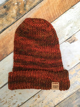 Load image into Gallery viewer, The Hadrosaur Hat is a lightweight, double layered slouchy beanie with folded brim.  It is shown here in orange/brown in a flat lay.
