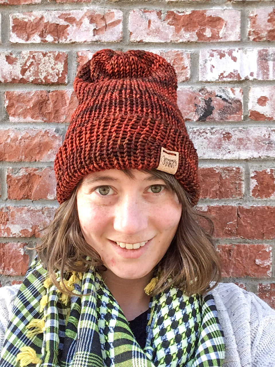 The Hadrosaur Hat is a lightweight, double layered slouchy beanie with folded brim.  It is shown here in orange/brown on a model.