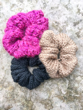 Load image into Gallery viewer, Three knit scrunchies are shown in a flat lay.  They are magenta, light brown, and black.
