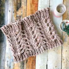 Load image into Gallery viewer, Flat lay of the Fossil Cowl in beige against a wooden background styled with a candle and jewelry dish
