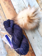 Load image into Gallery viewer, Skein of blue yarn with white/brown pom.
