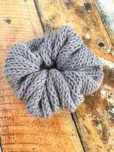 Load image into Gallery viewer, The Cotton Scrunchy is a simple knit hair accessory. It is show here in gray in a flat lay.
