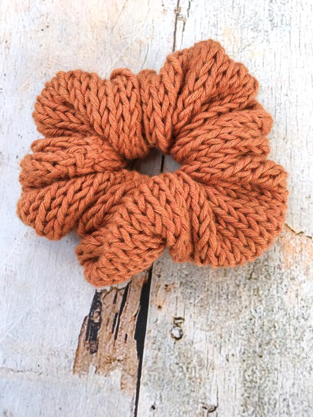 The Cotton Scrunchy is a simple knit hair accessory. It is show here in copper in a flat lay.