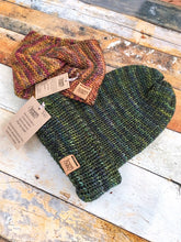 Load image into Gallery viewer, A folded brim beanie and knotted headwrap in flat lay.  The beanie is made with green tones, and the wrap is made with pink and gold tones.
